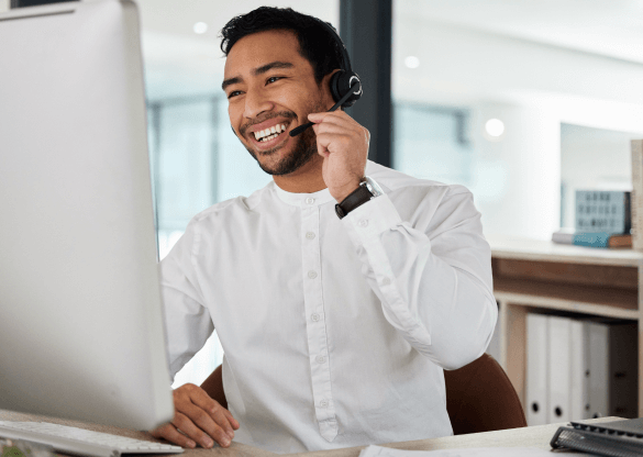 A member of customer support smiles while wearing a wireless headset