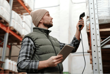 A man scanning product in a storage warehouse