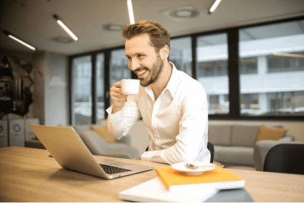 A businessman drinking coffee with his laptop